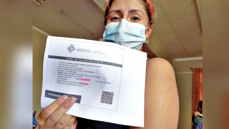 MUJER MUESTRA SU CARNET DE VACUNACION