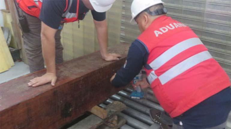 Los funcionarios de Aduana de Chile revisando la madera