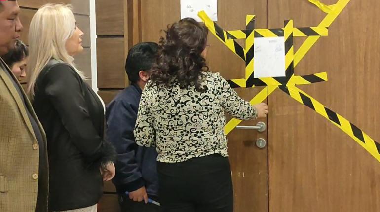 El presidente de la Comisión Mixta de Justicia Plural, Roberto Padilla, desprecinta el ambiente en presencia de una notaria de fe pública